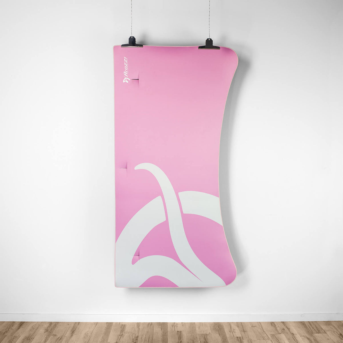 Arozzi Europe Arena Mousepad in pink and white hangs above a wooden floor.