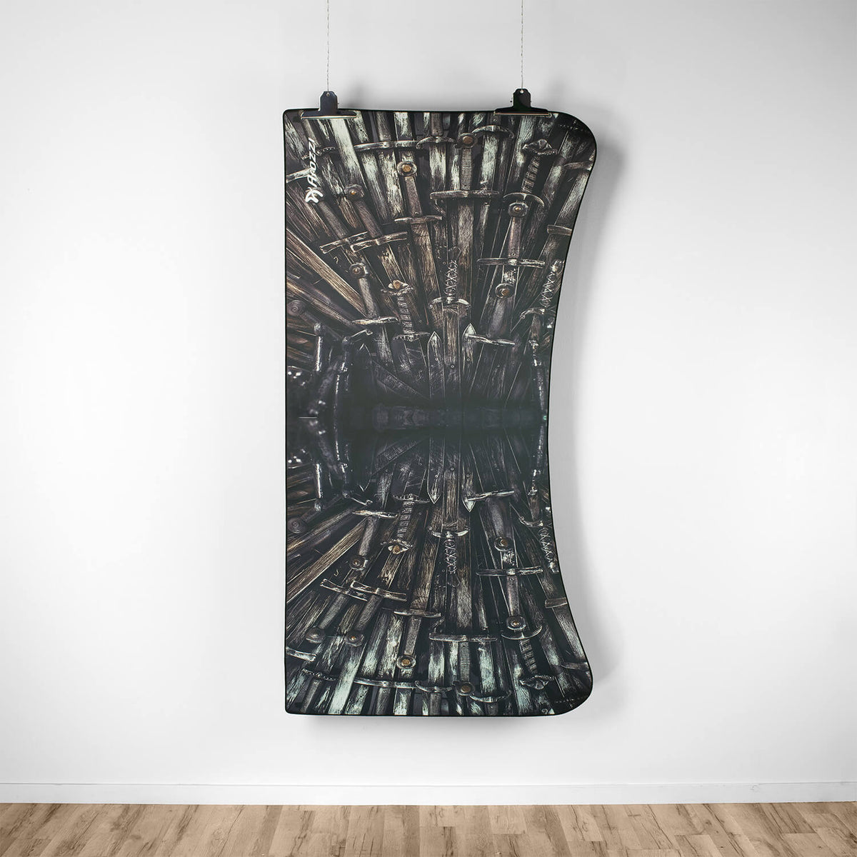 Arozzi Europe Arena Mousepad with sword print curves above a wooden floor.