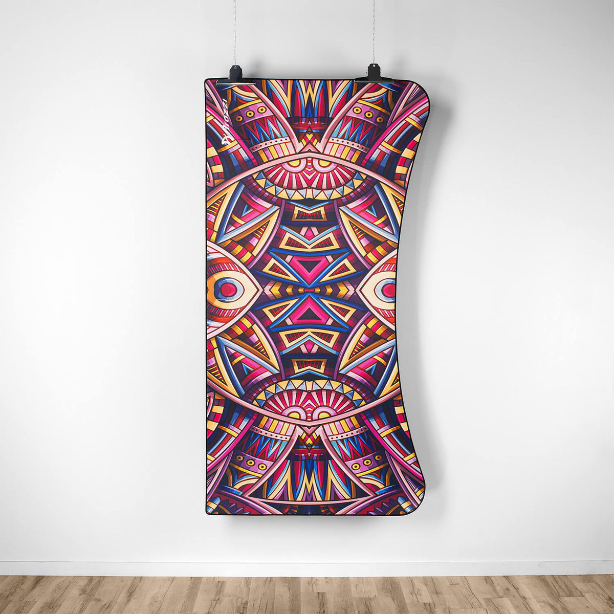 Abstract geometric art hangs above a wooden floor, next to an Arozzi Europe Arena Mousepad.