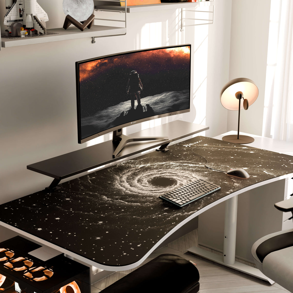 Curved monitor, keyboard, Arozzi Europe Arena Mousepad on galaxy desk with lamp and space decor.