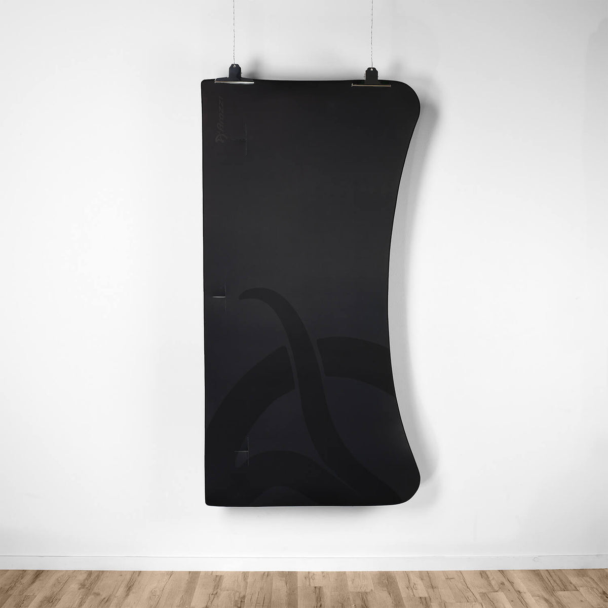 Arozzi Europe Arena Mousepad (large, black) hangs on a white wall above a wooden floor.