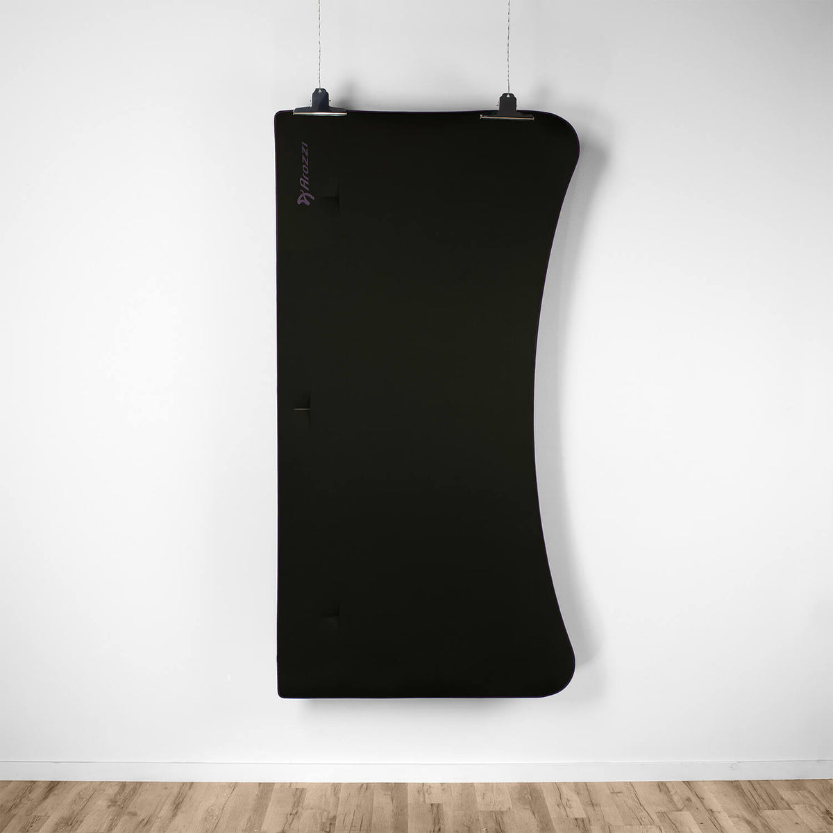 A black curved acoustic panel hangs above a wood floor and an Arozzi Europe Arena Mousepad.