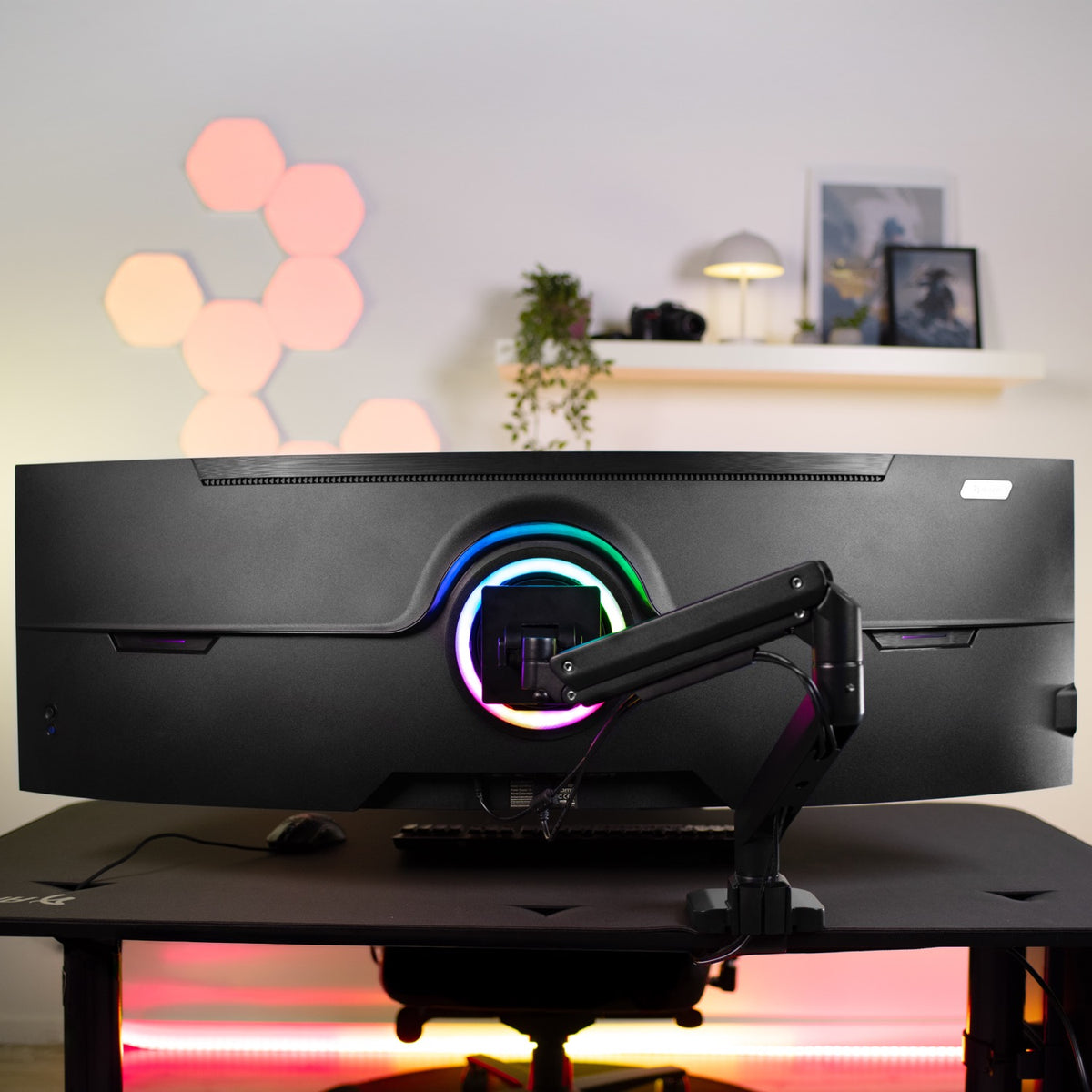 Curved monitor on Alzare Neo Pro arm by Arozzi Europe, RGB desk lights, hexagons, shelves behind.