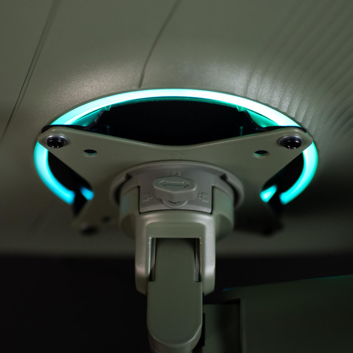 Close-up of a gray mount with a glowing blue-green ring and arrow symbol.
