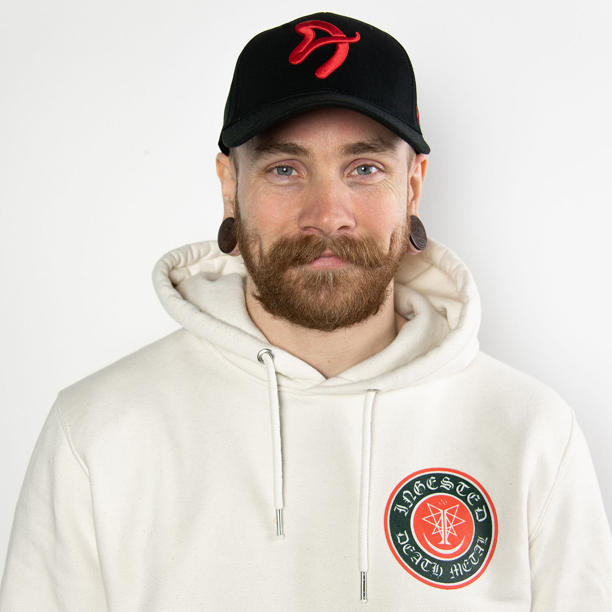 Man with a beard in a white hoodie and Arozzi Europe Sport Cap with adjustable metal clip.
