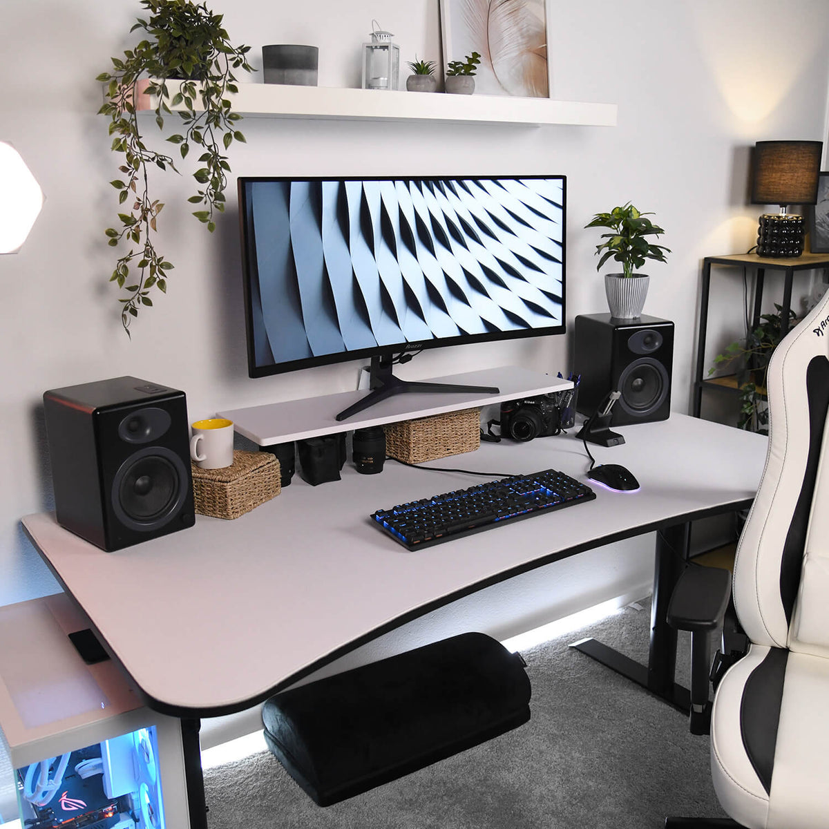 Minimalist desk setup with Arozzi Europe Desk Riser - Small, keyboard, speakers, camera, and plants.
