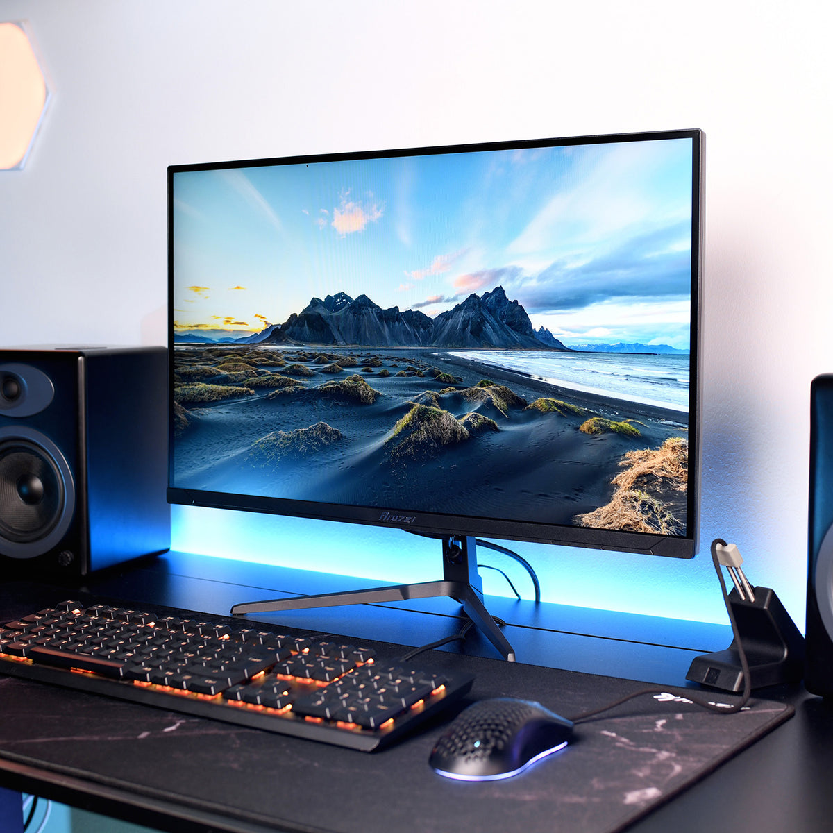 Arozzi Europe Nova 27″ IPS 260Hz monitor on a desk shows mountains, with keyboard and mouse nearby.