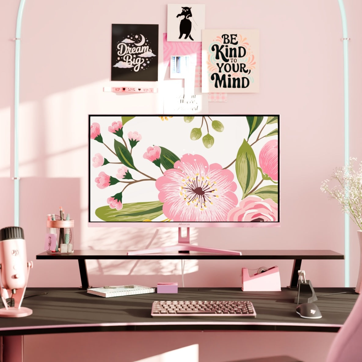 Pink desk setup with Nova 32″ IPS 180Hz QHD monitor by Arozzi, keyboard, and floral wall art.