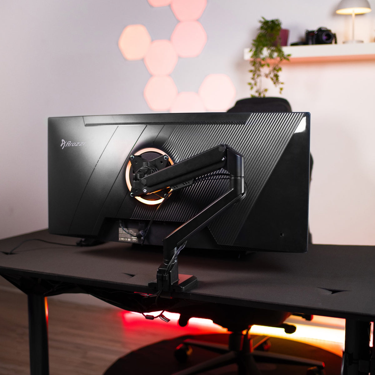 Arozzi Europe Nova 34″ Curved VA 165Hz gaming monitor on arm mount sits on black desk.