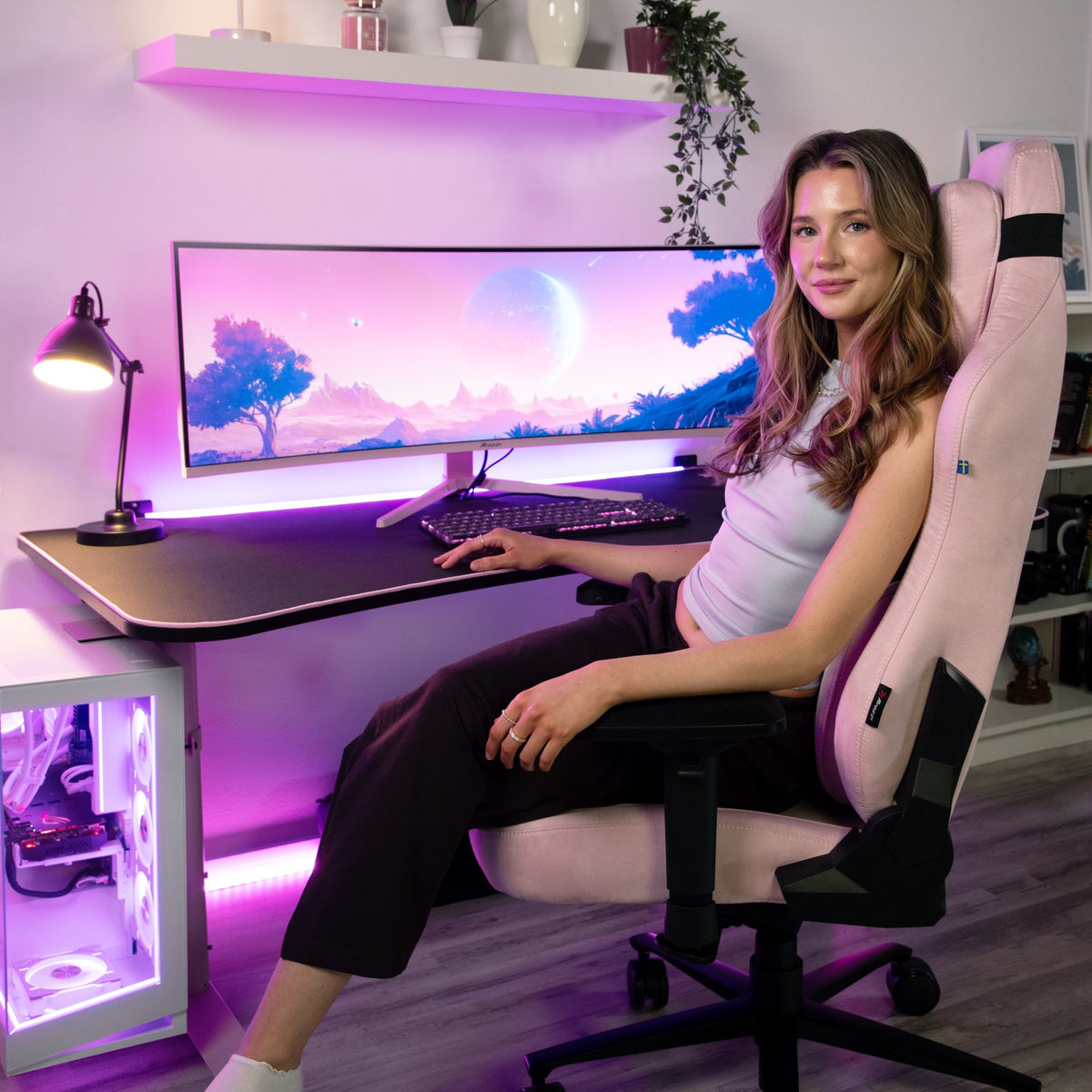 Woman at desk with Arozzi Nova 49″ Curved VA 165Hz Ultrawide Monitor, purple landscape backdrop.