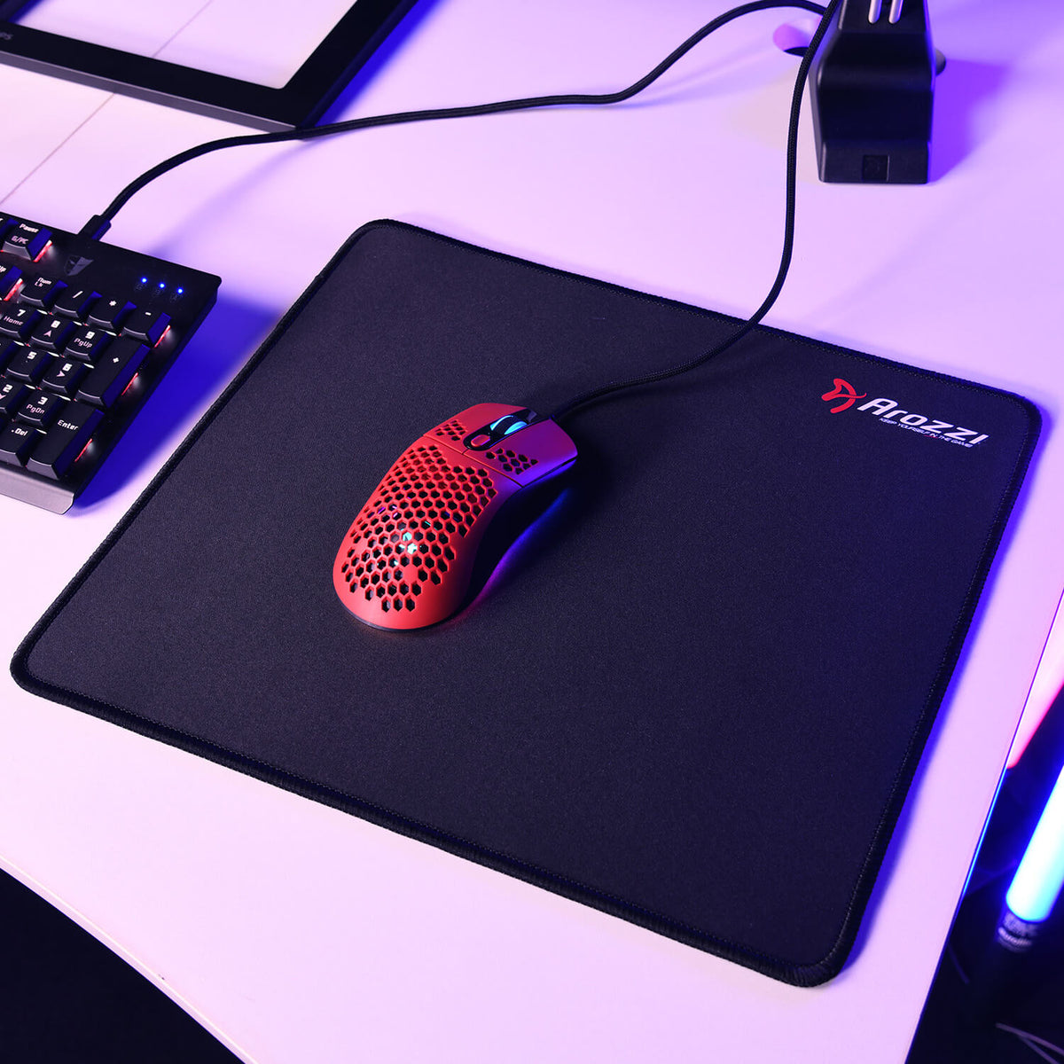 Red wired mouse on Arozzi Europe Zona Mousepad - Small, beside a keyboard on white desk.