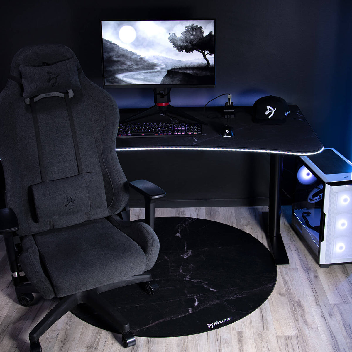 Arozzi Europe Zona Round Floor Pad featured in a modern gaming setup with chair, desk, and gear.