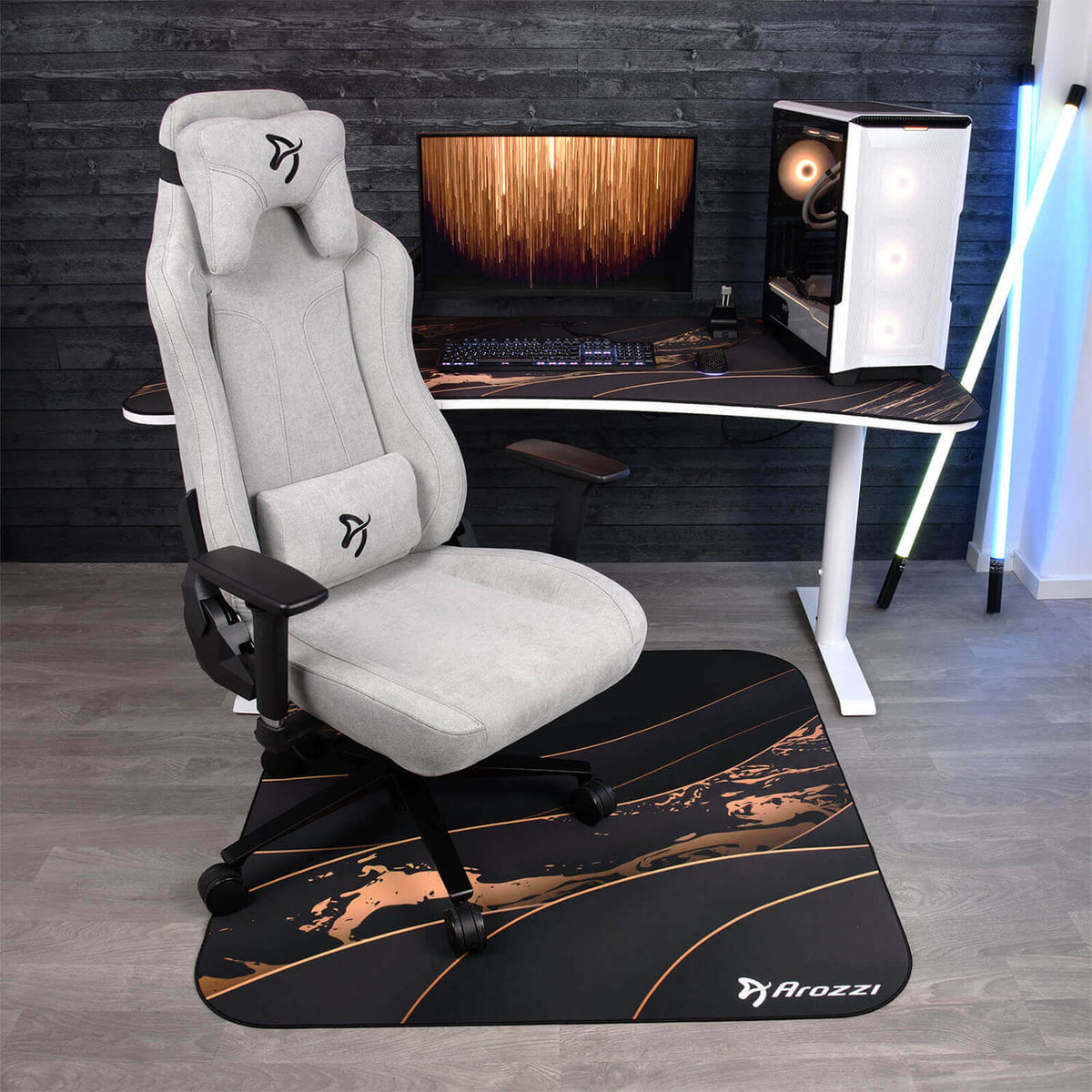 Gray gaming chair on an Arozzi Europe Zona Square Floor Pad in front of a desk with monitor and PC.