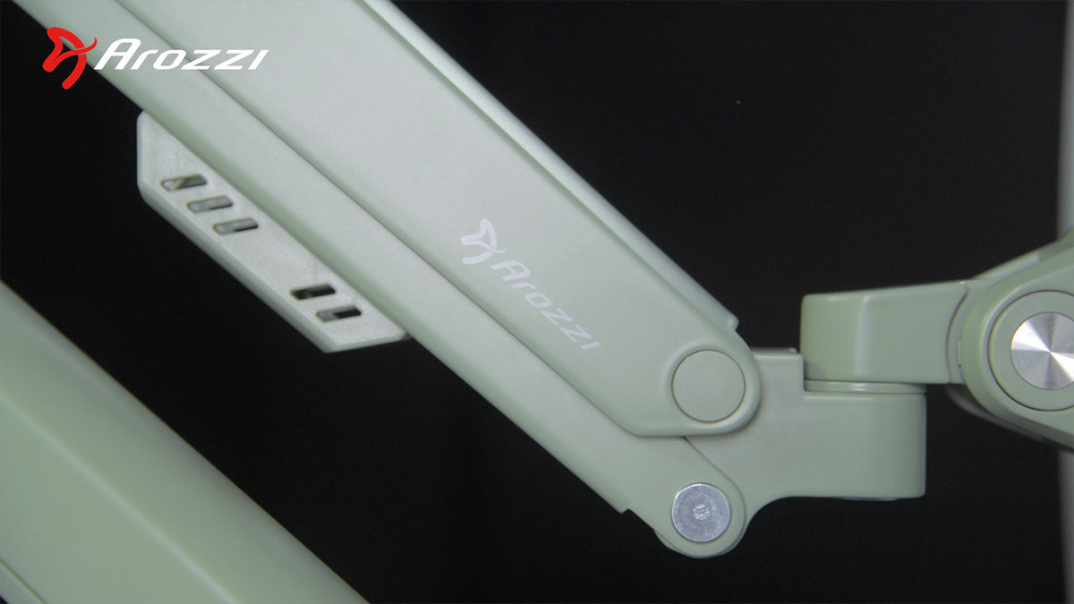 Close-up of a green Arozzi chair armrest with logo and metal adjustment mechanism visible.