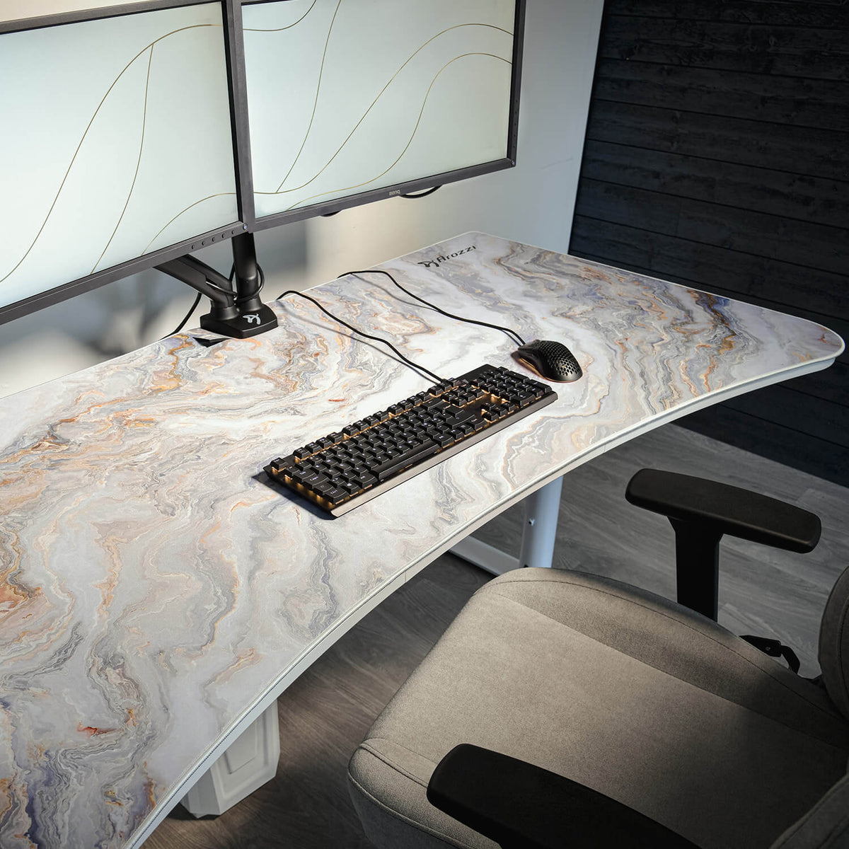 Curved desk, Arena Mousepad by Arozzi Europe, keyboard, dual monitors, gray office chair.