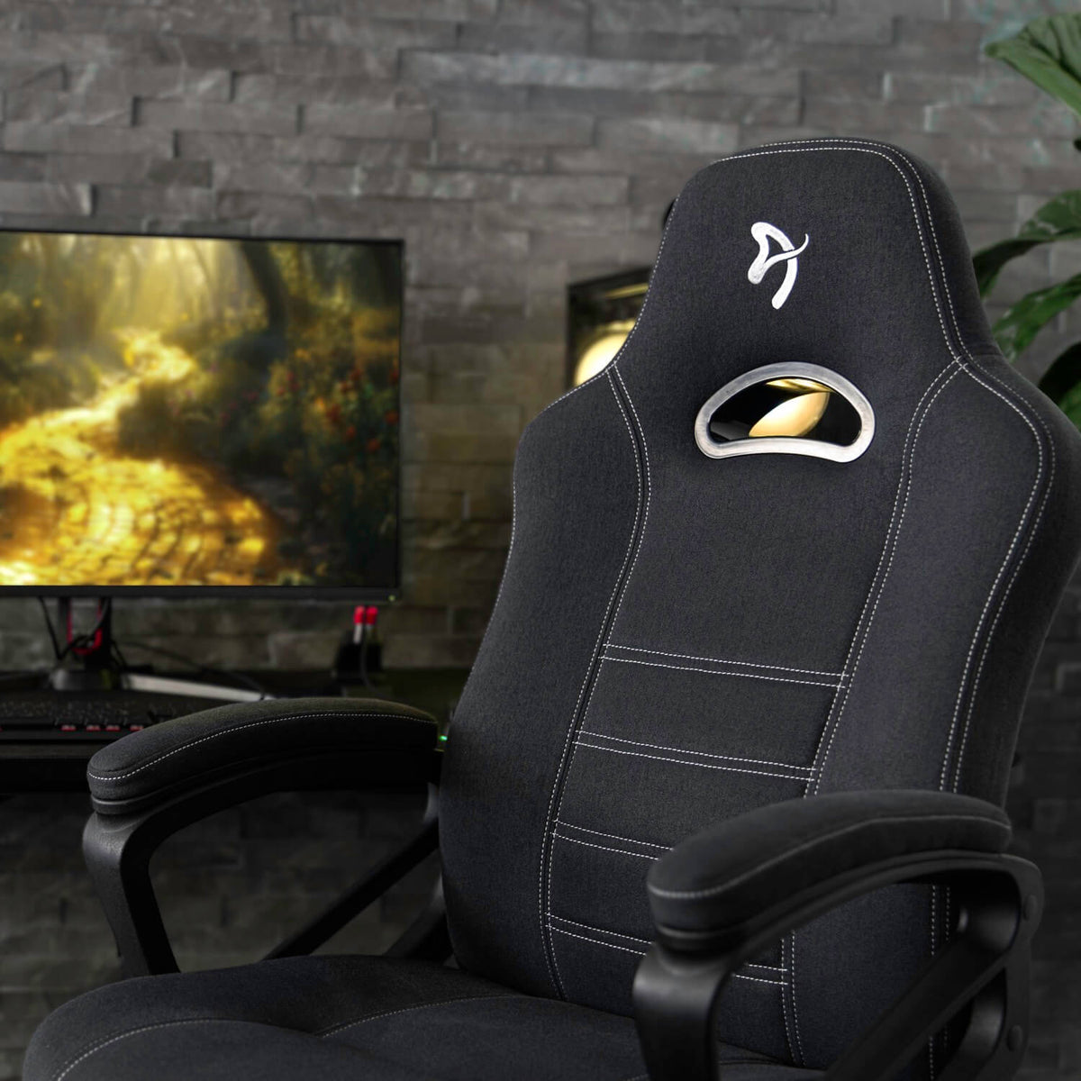 Arozzi Europe Enzo Woven Fabric chair at a desk, monitor displays a forest path scene.
