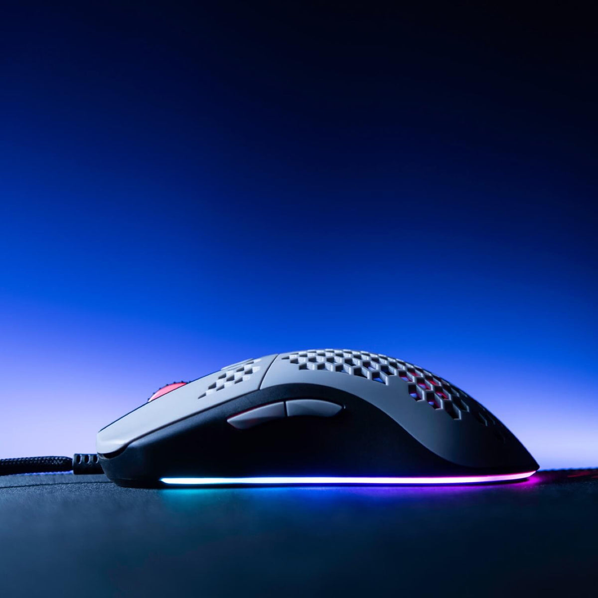 Arozzi Favo Ultra Light Gaming Mouse with RGB lighting on a mousepad, blue gradient background.