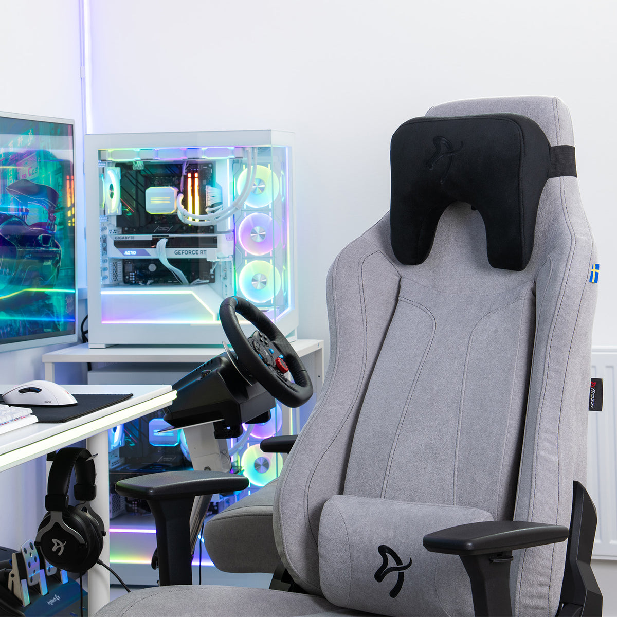Gray gaming chair with Arozzi Europe Velvet Black Neck Support Pillow; RGB-lit gaming PC behind.