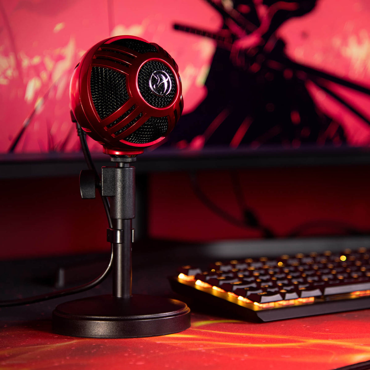 Arozzi Europe Sfera Microphone on stand near lit keyboard, monitor glowing softly behind.