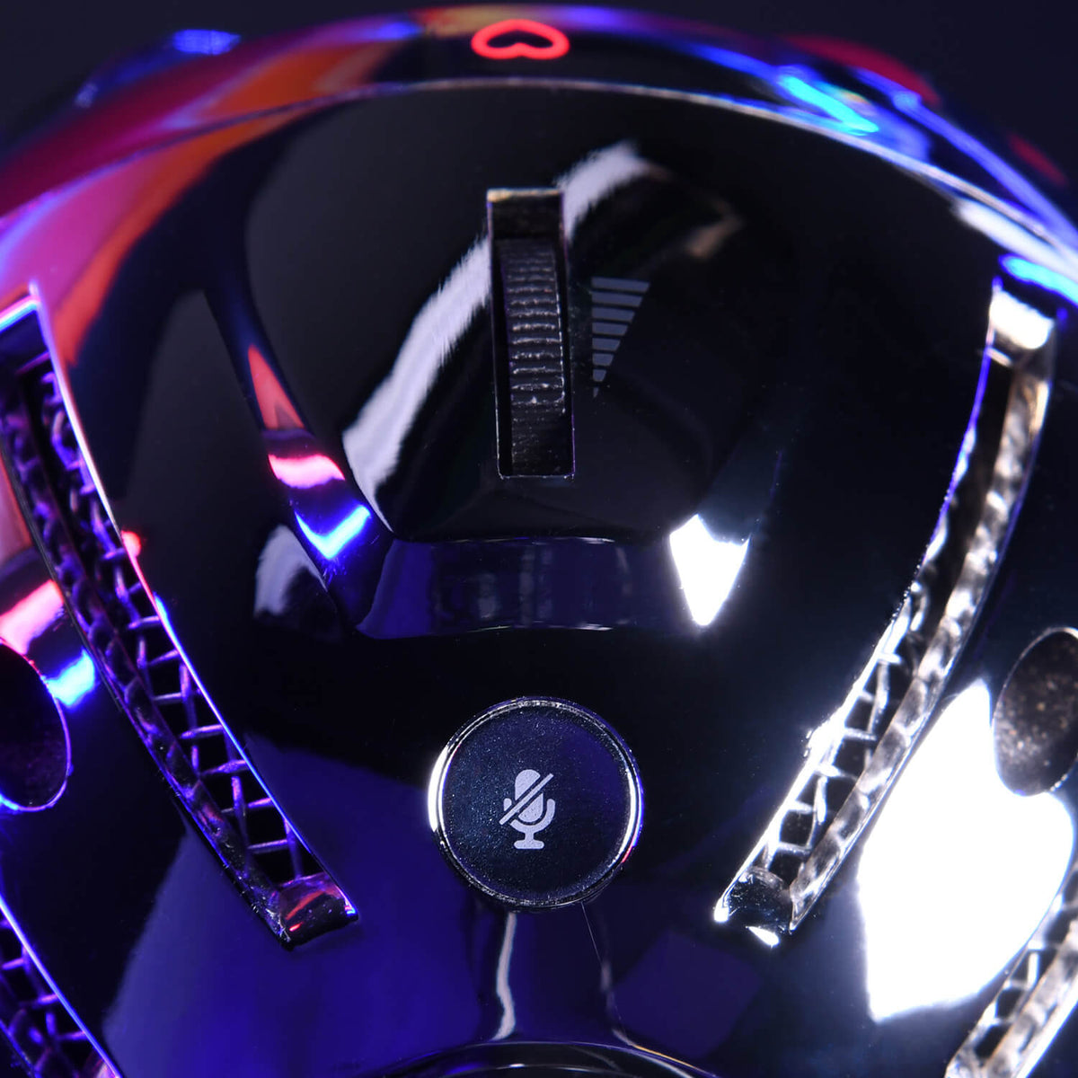 Close-up of a shiny microphones mute button with colorful reflected lights.