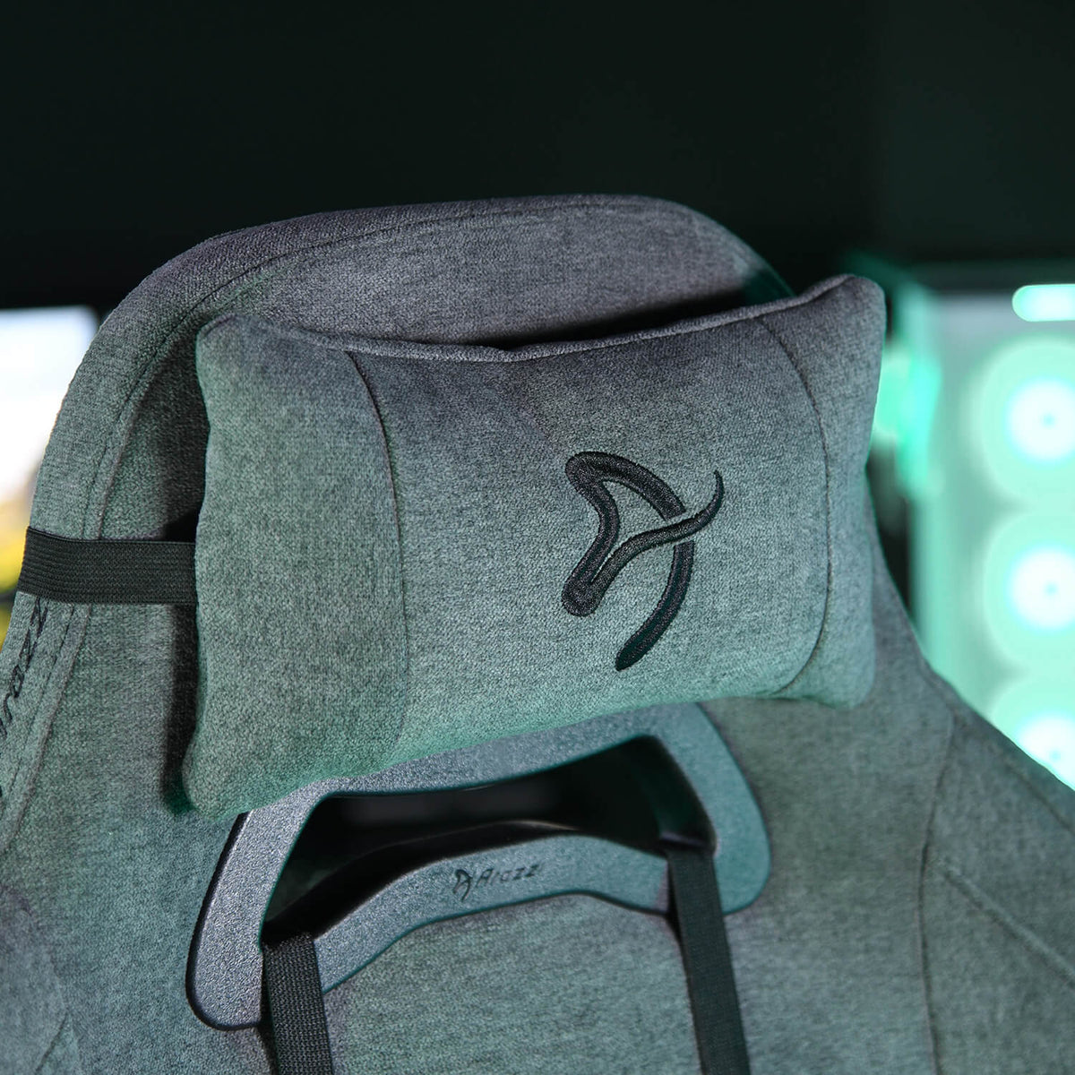 Gray gaming chair with a matching headrest pillow, both featuring a stitched black logo.