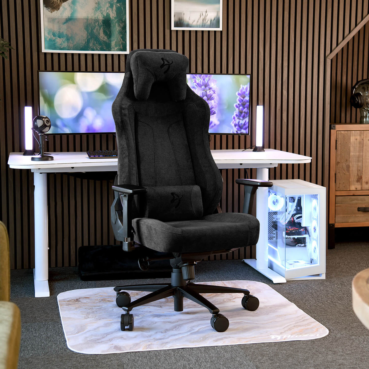 Arozzi Europe Vernazza Soft Fabric black gaming chair with adjustable height on a rug by a PC.