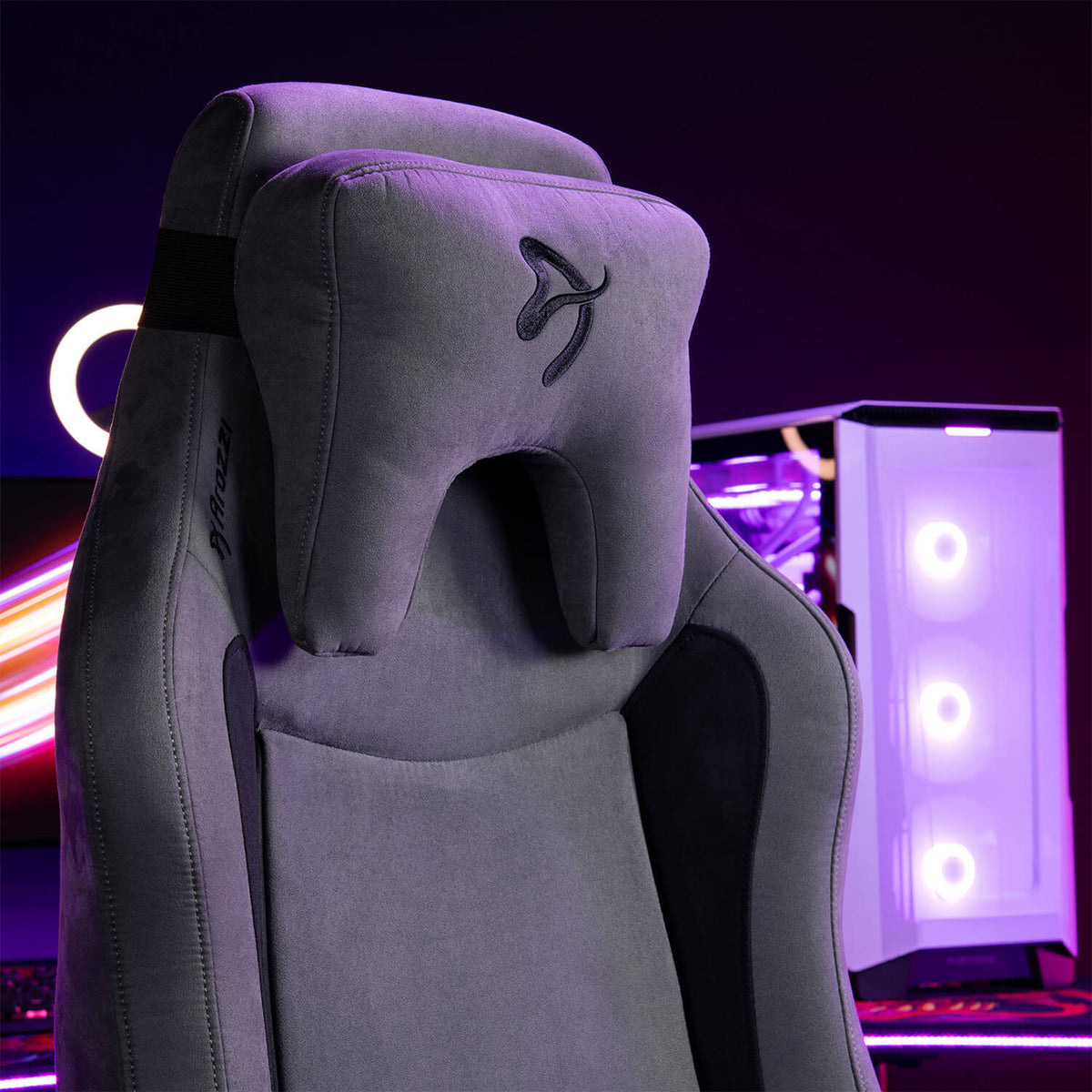 Arozzi Europe Vernazza Supersoft gaming chair with headrest before a white PC, purple lights.