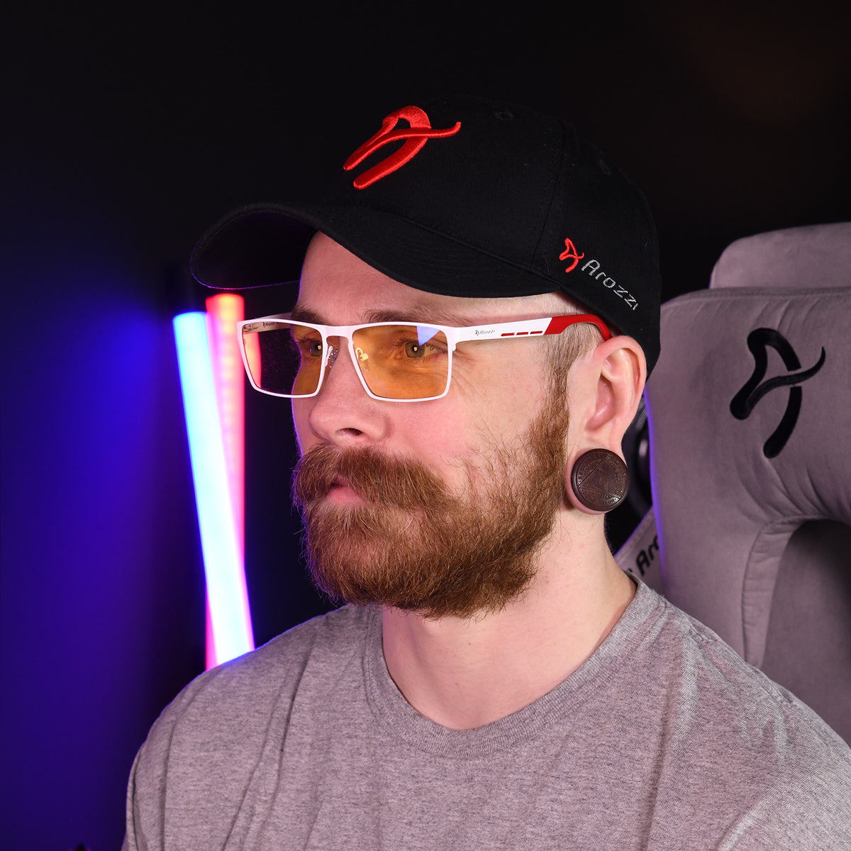 Bearded man wears Arozzi Europe Visione VX-800 blue light glasses, seated in a chair.