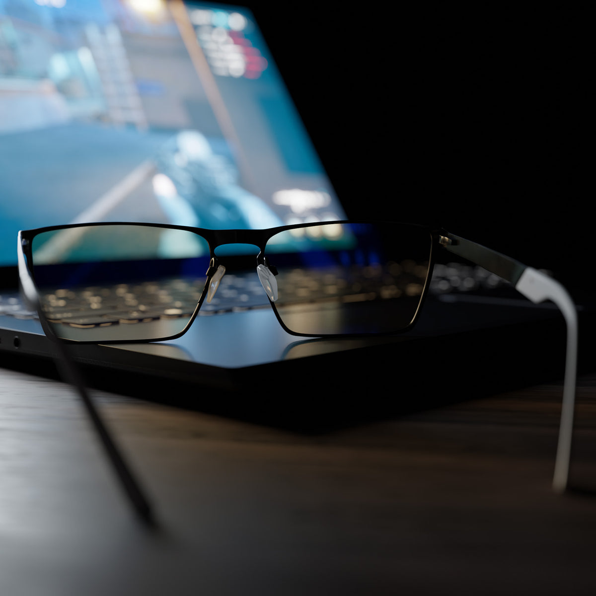 Arozzi Europe Visione VX-800 black glasses rest on laptop, shielding eyes from blue light.