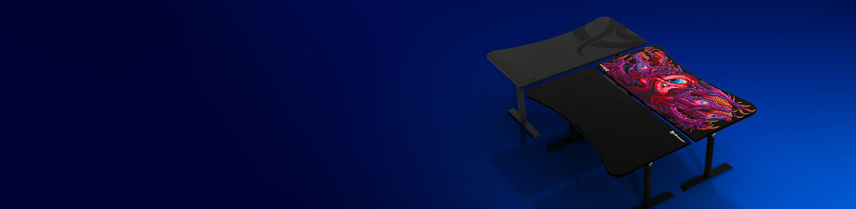 Curved black gaming desk with a colorful dragon mousepad on a blue gradient background.