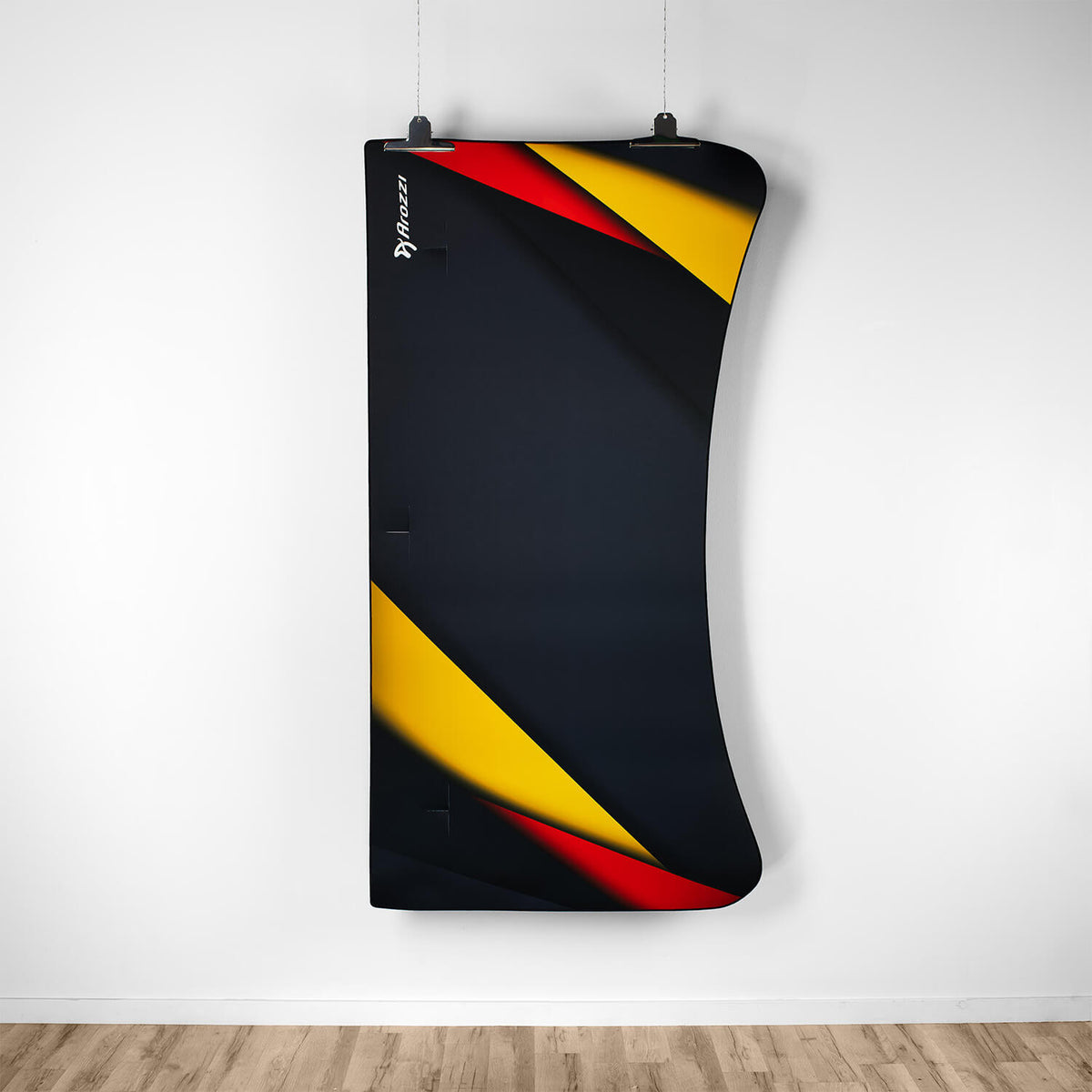 Arozzi Europe Arena Mousepad with black, red, yellow geometric design hangs on a white wall.