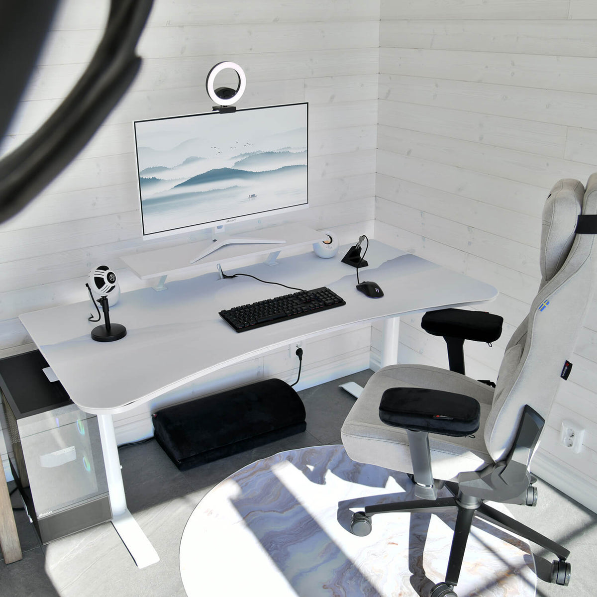 Minimalist white desk with Arozzi Europe Arena Mousepad, computer, mic, webcam, and ergonomic chair.