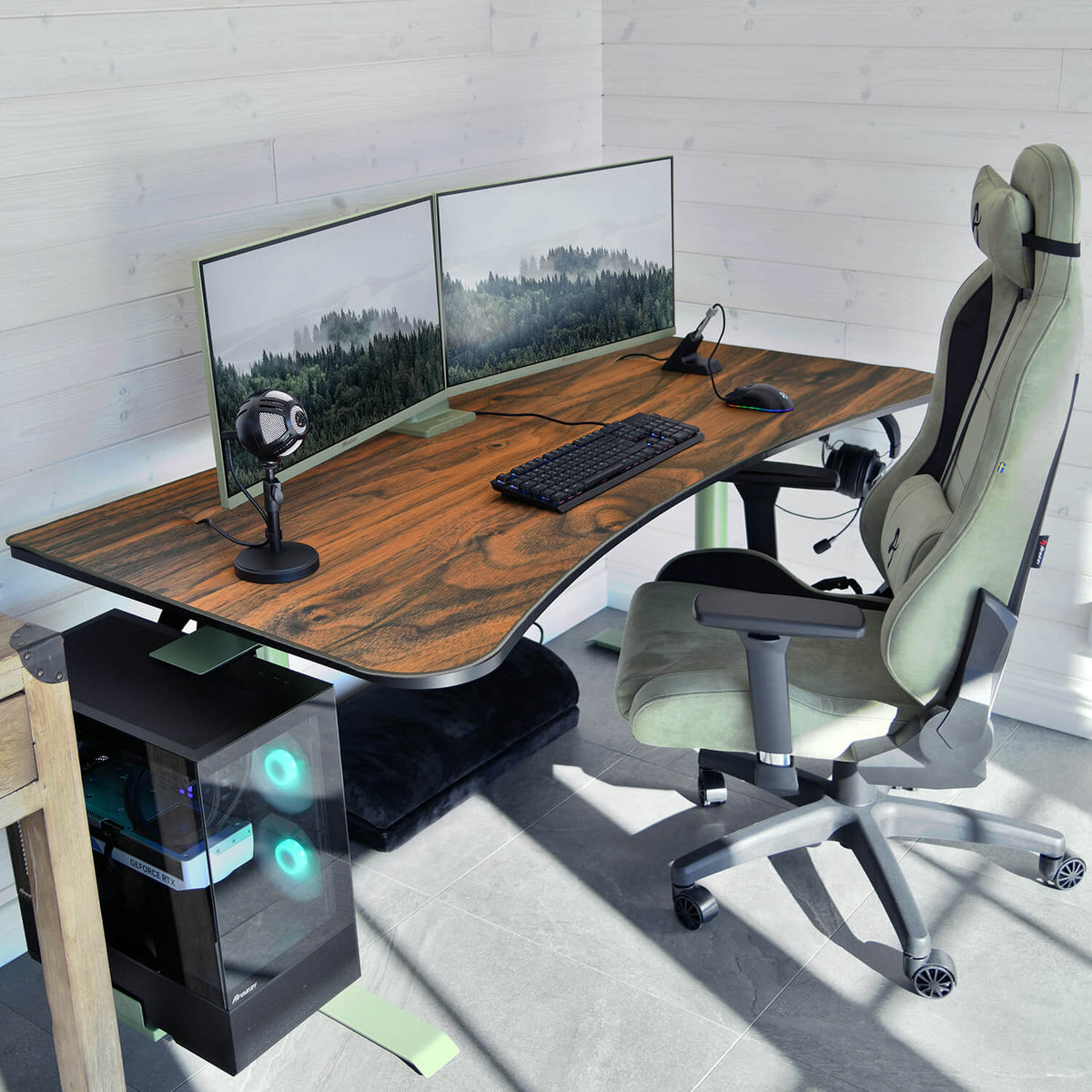 Dual monitors on wood desk with keyboard, mouse, Arozzi Arena Mousepad, mic, and gaming chair.