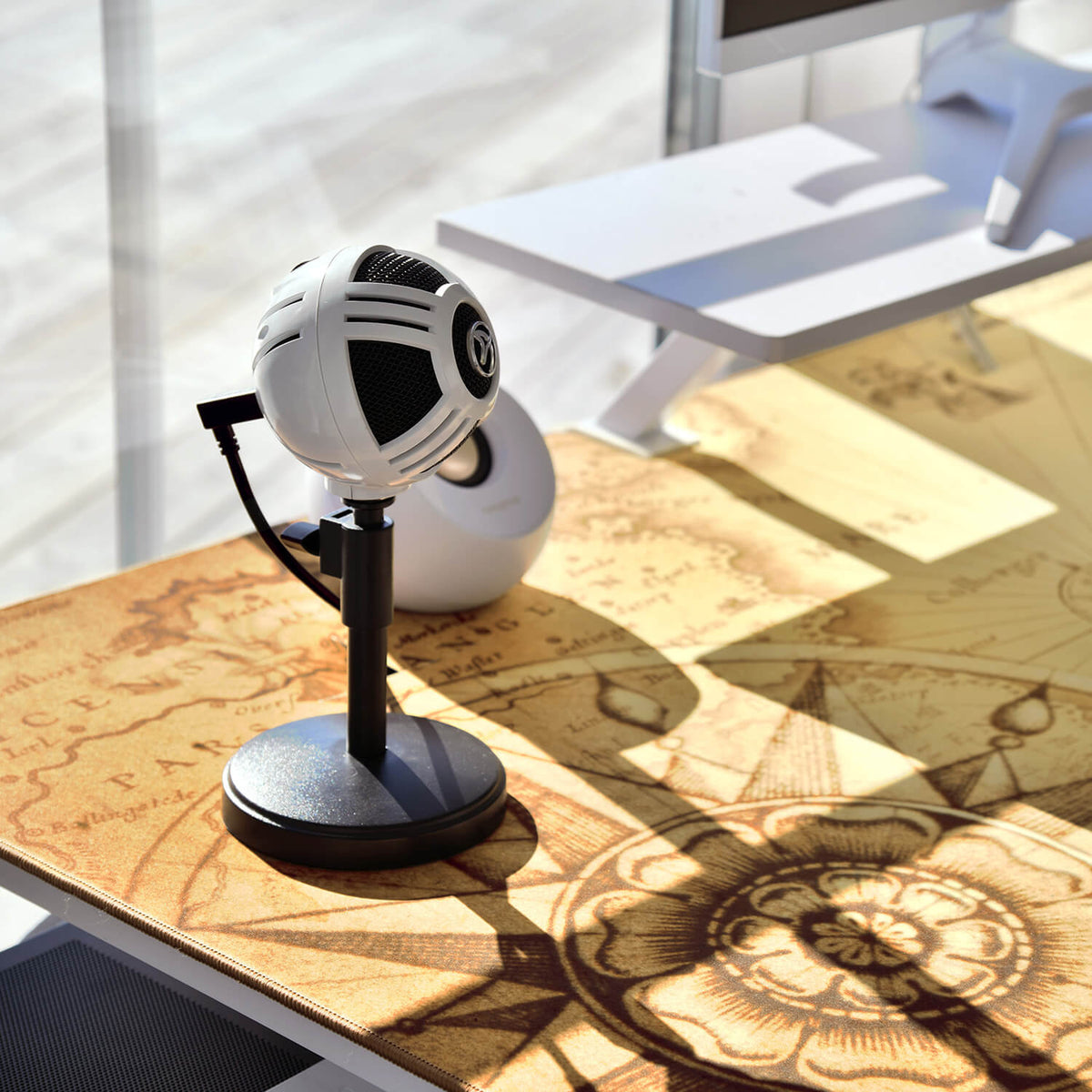 Arozzi Europe Arena Mousepad with map design on desk; white spherical mic on stand nearby.