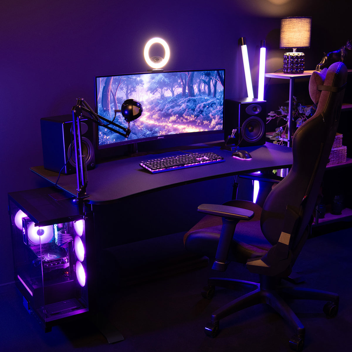 A gaming setup with purple LEDs, curved monitor, speakers, and an Arozzi Arena Medium Mousepad.