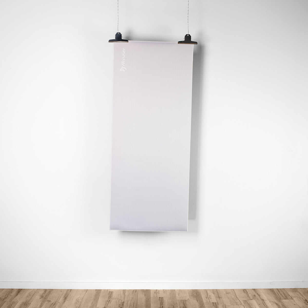 A white screen hangs above a desk with an Arozzi Arena Nordico mousepad on light wood floor.