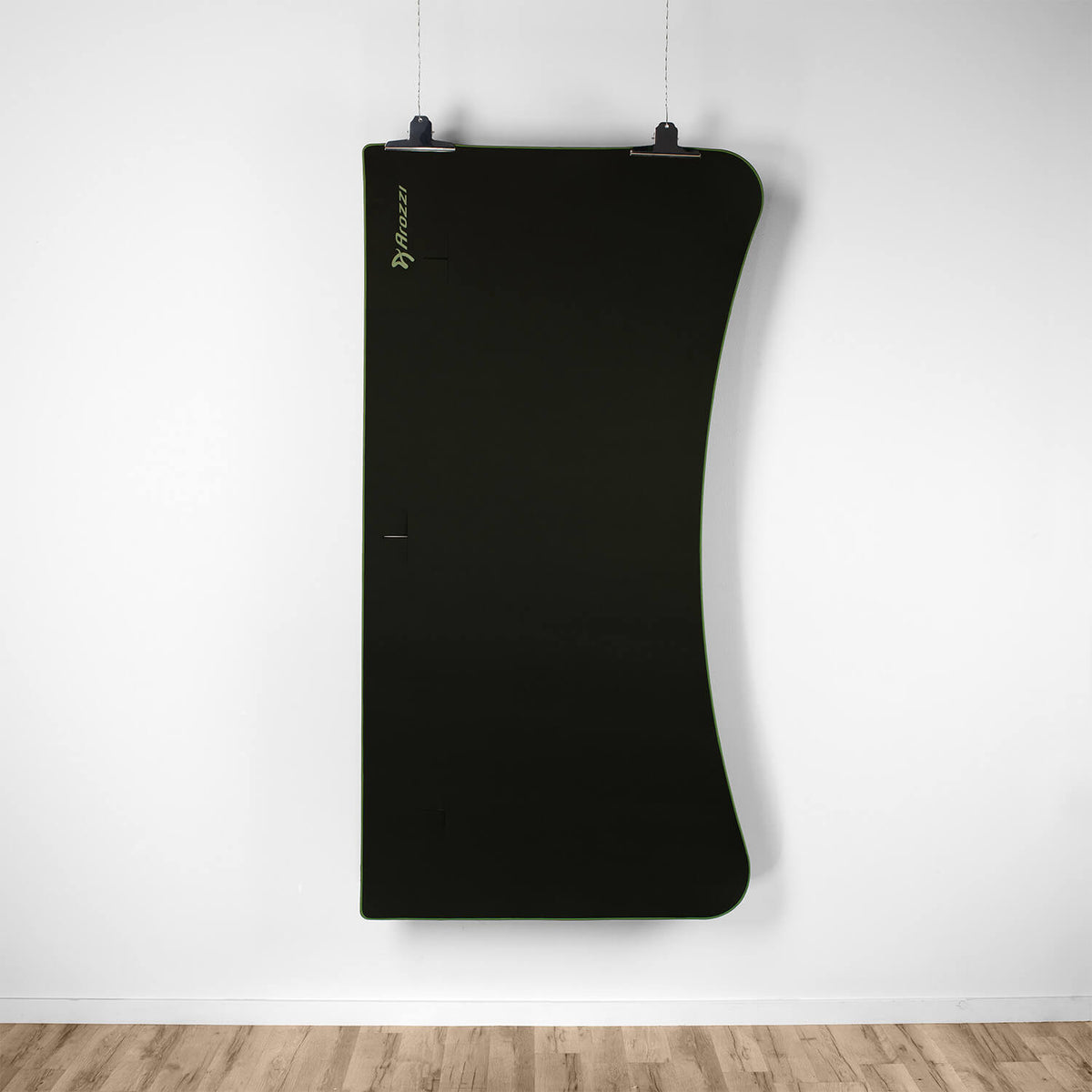 Arozzi Europe Arena Mousepad, large black, hangs on a white wall above wooden flooring.