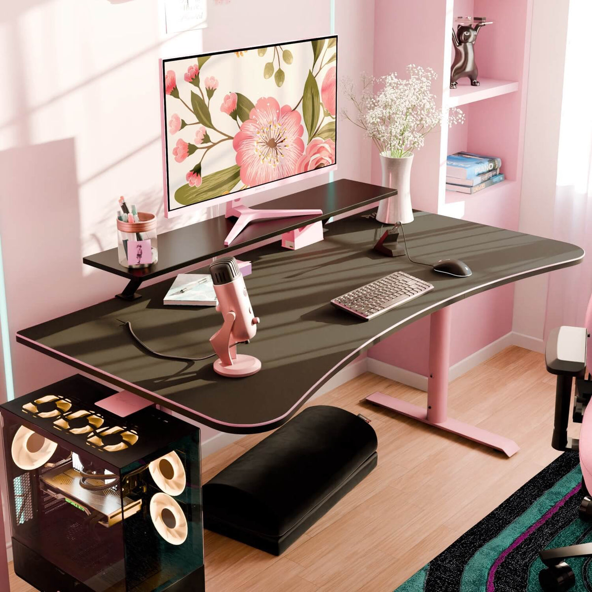 Arozzi Arena Gaming Desk - Large in a pink-black setup with floral wallpaper and sunlight accents.