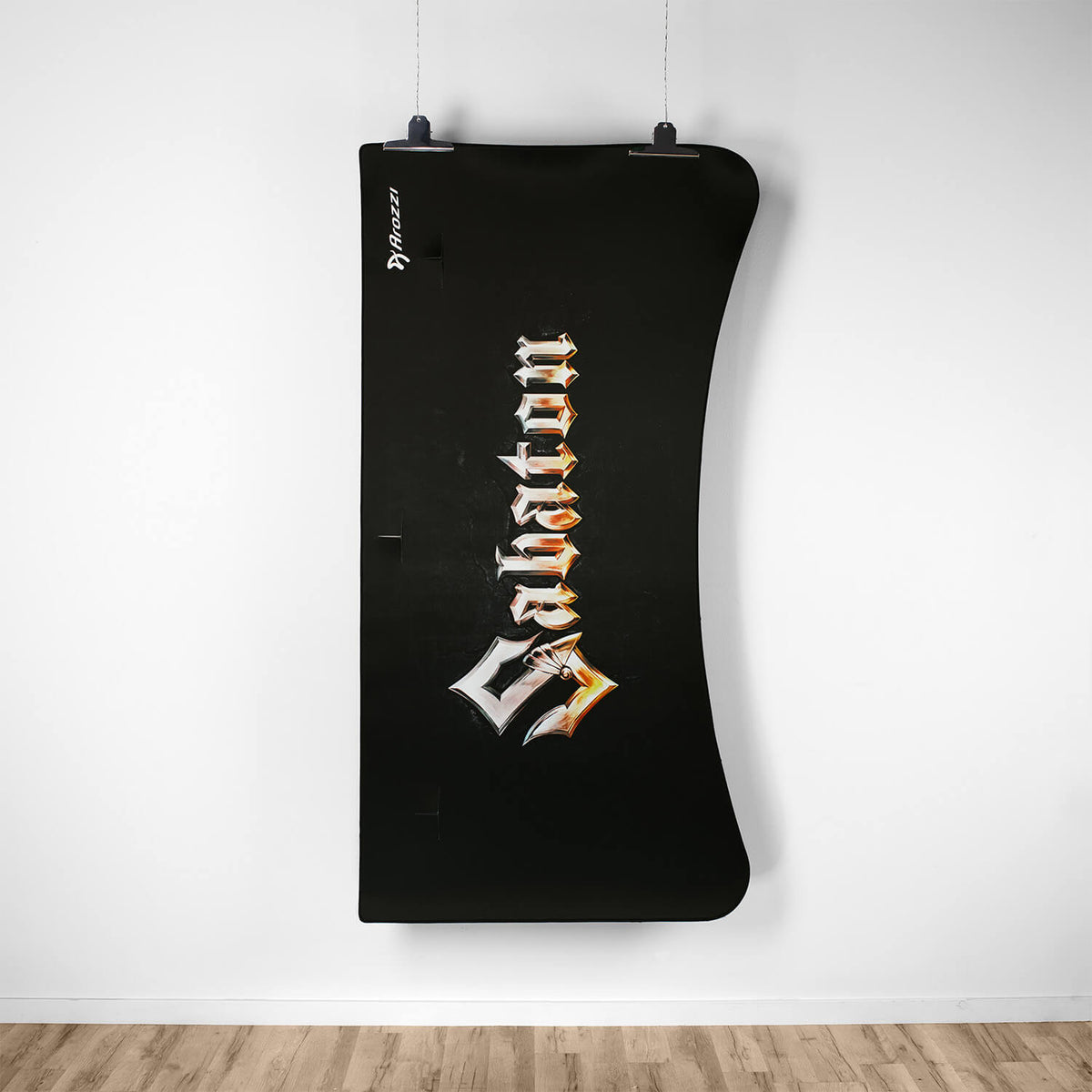 Black curved Arena Mousepad by Arozzi Europe, “Salvation” text, hangs on a white wall.