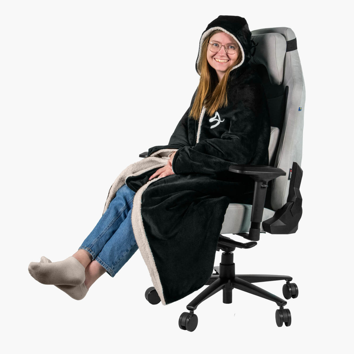 Person in a black Arozzi Europe Chair Blanket sits cross-legged on a gray office chair.