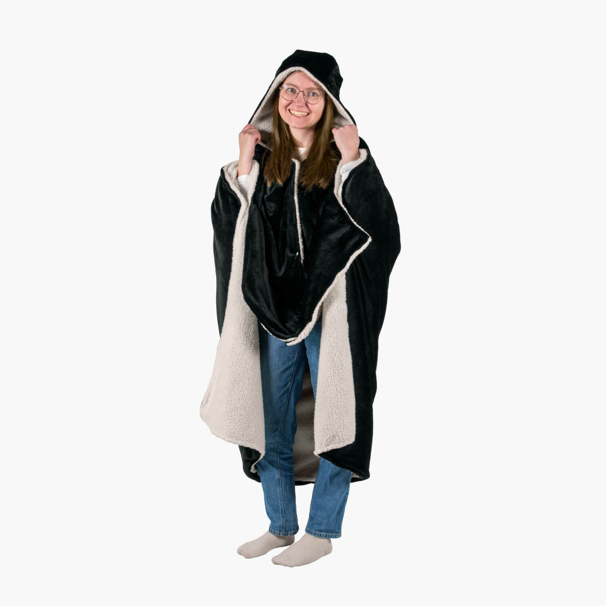 Smiling person in glasses wearing Arozzi Europe’s Chair Blanket, a cozy black and white sherpa.