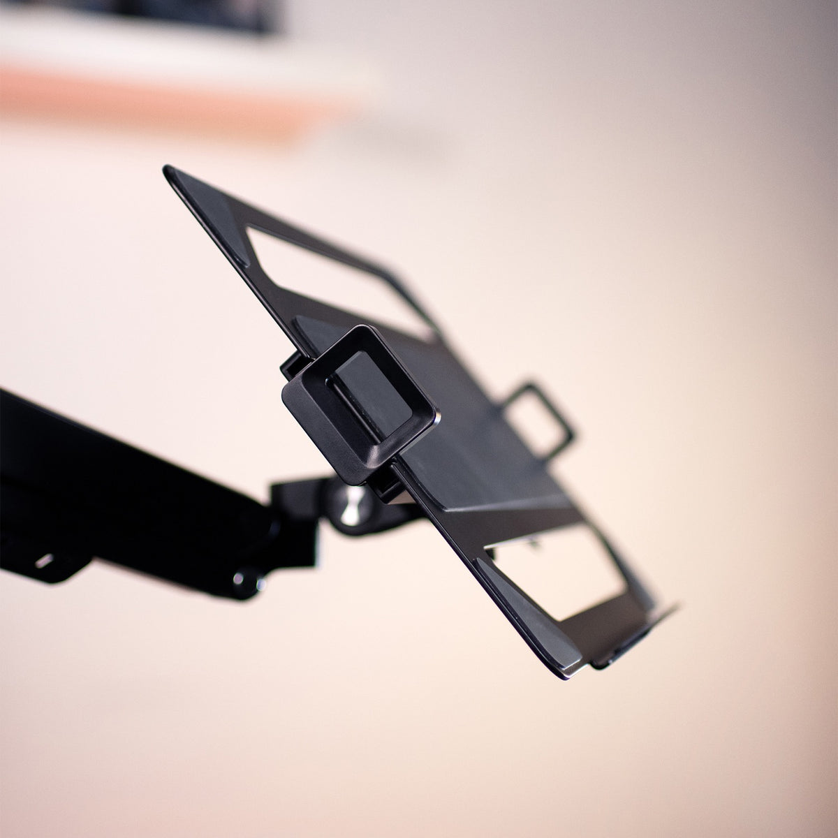 Arozzi Europe Alzare black metal laptop holder with slots, mounted on a monitor arm.
