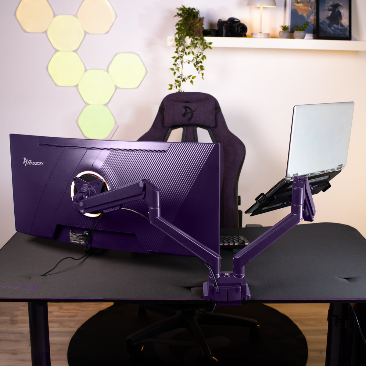 A desk with a purple monitor, Alzare Neo Duo arm by Arozzi Europe, and a gaming chair.
