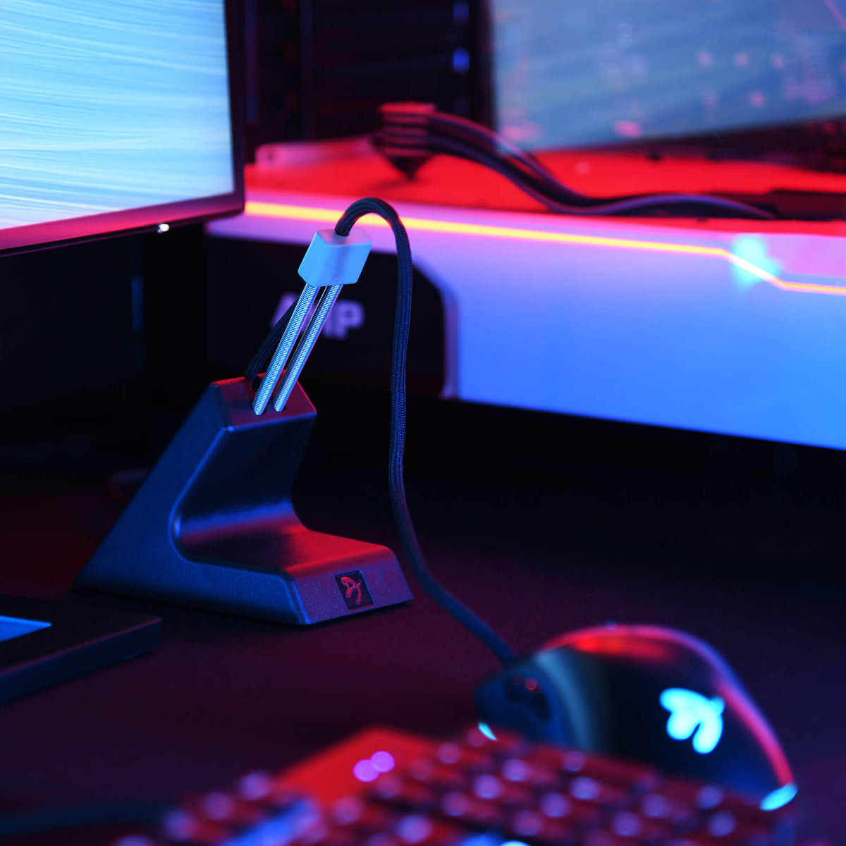 Arozzi Europe Ancora Mouse Cable Holder on desk, accented by vibrant gaming lights.