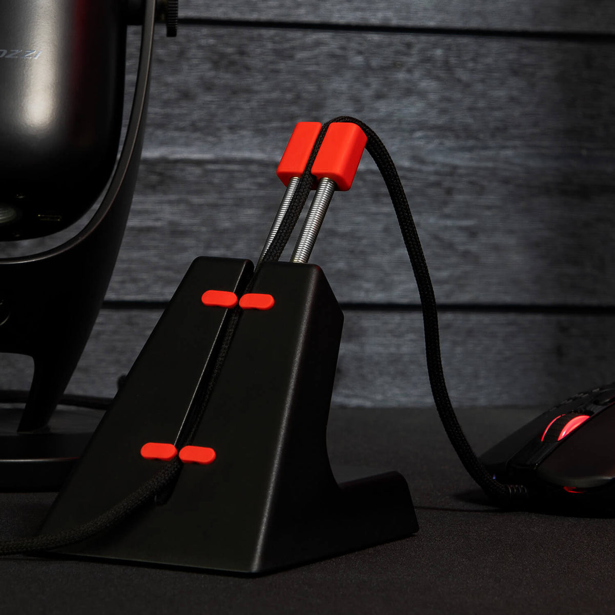 Arozzi Europe’s Ancora Mouse Cable Holder manages your wired mouse on a dark desk.