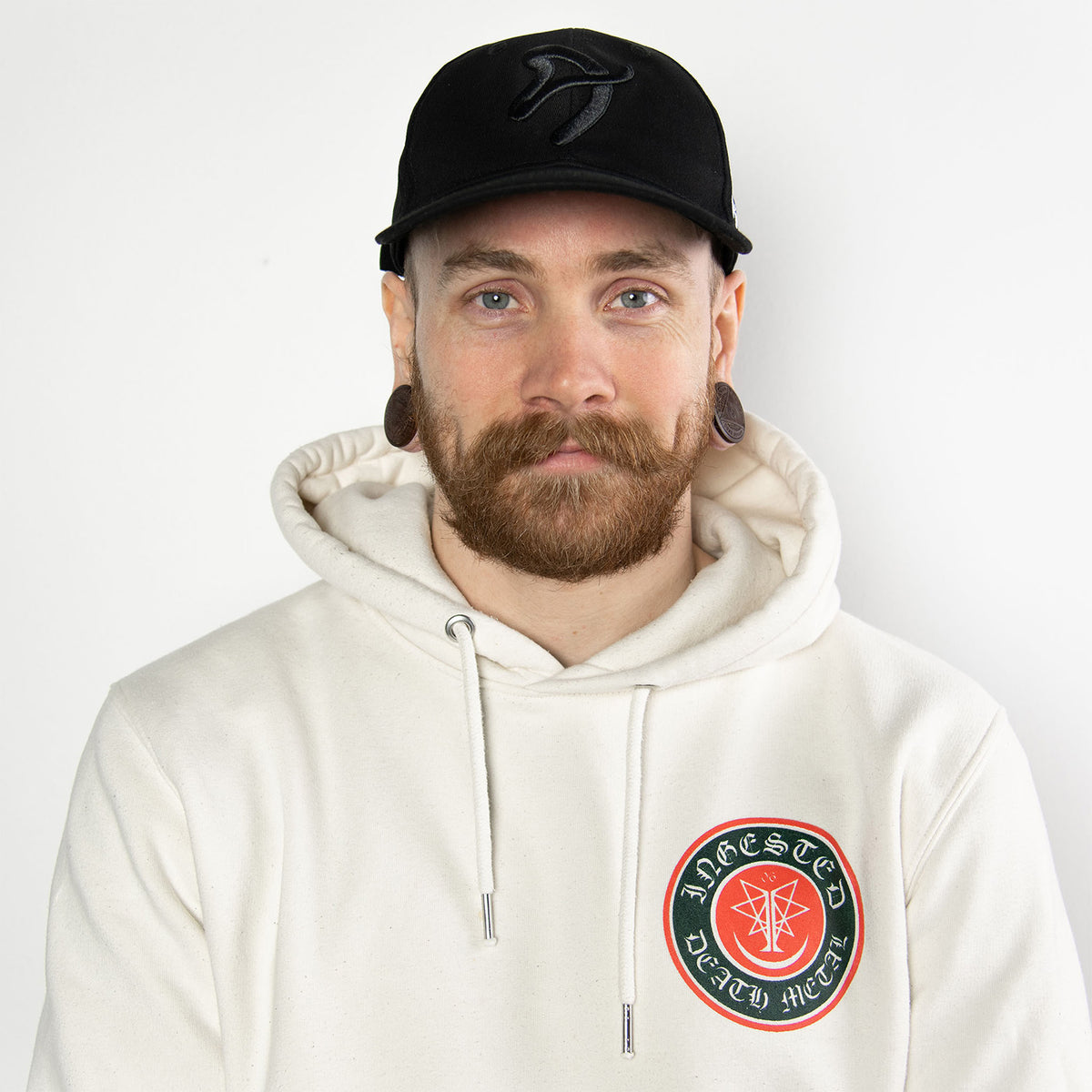 Man with mustache in Arozzi Europe Sport Cap and white hoodie with circular patch.