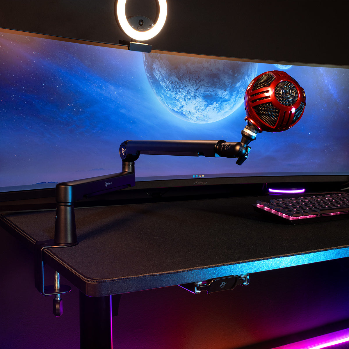 Curved monitor, ring light, red mic on Arozzi Europe Braccio arm, and RGB lights on black desk.