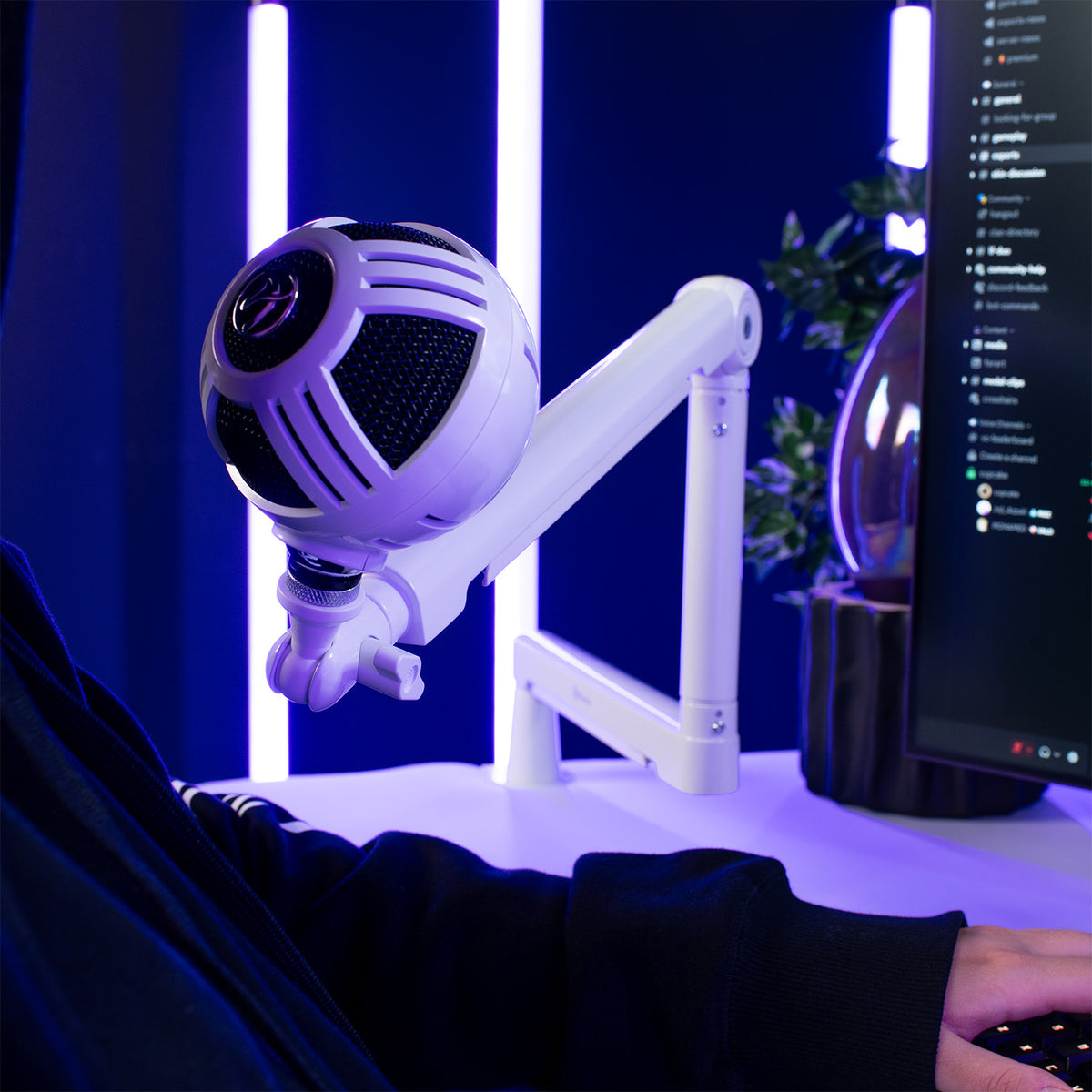 Arozzi Europe Braccio Microphone Boom Arm holds a white mic by a computer with blue-purple lights.