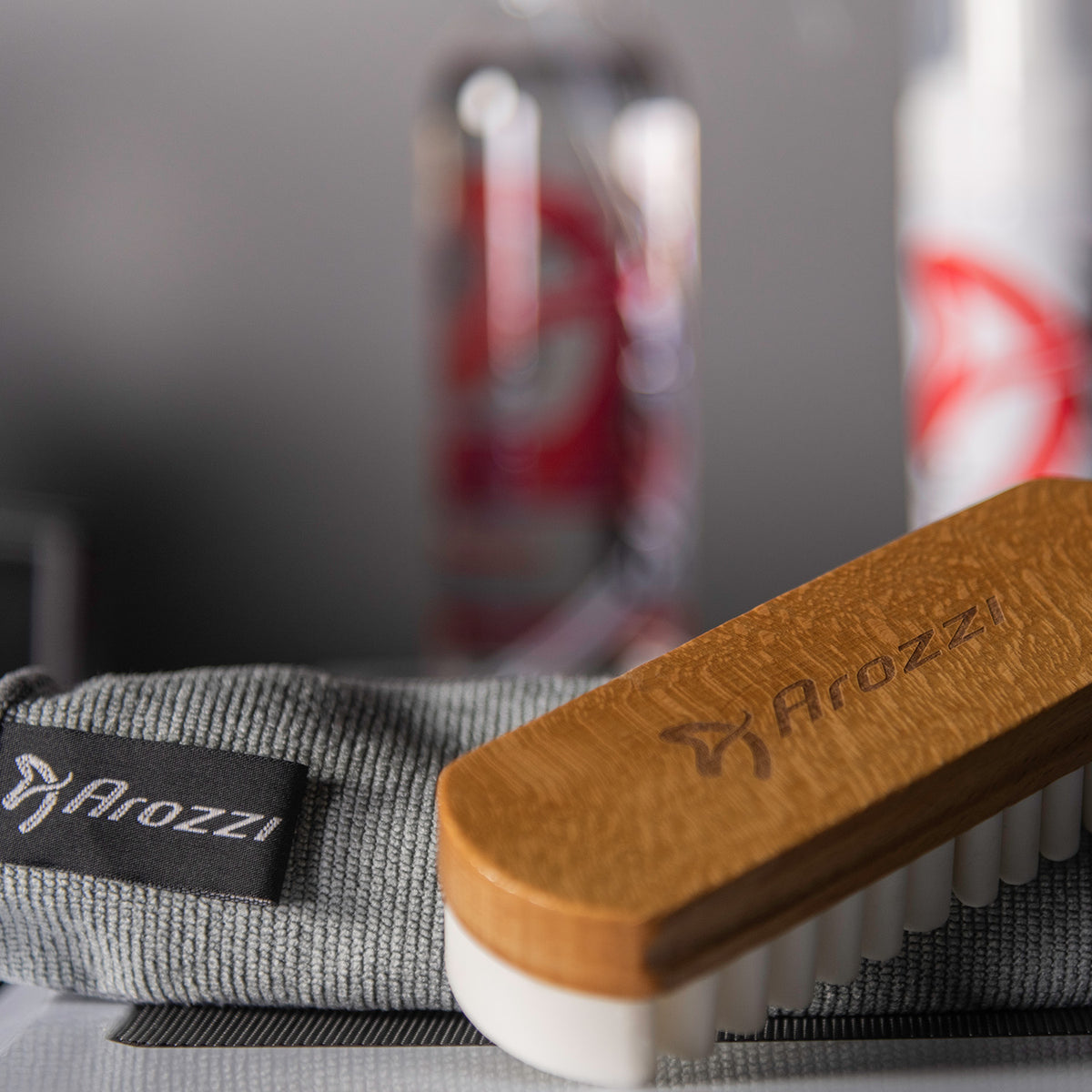 Arozzi Europe Cleaning Kit: wooden brush & gray cloth for premium fabric care.