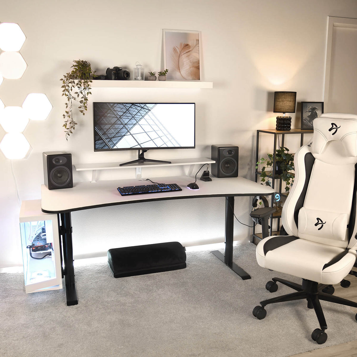 Minimalist setup with Arozzi Europe Desk Riser - Large, speakers, white chair, and wall decor.